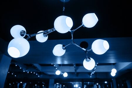 A modern chandelier hangs from the ceiling.の写真素材