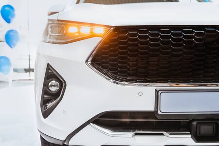 Led headlights and fog lights of a car. The car is white. Front view.の写真素材