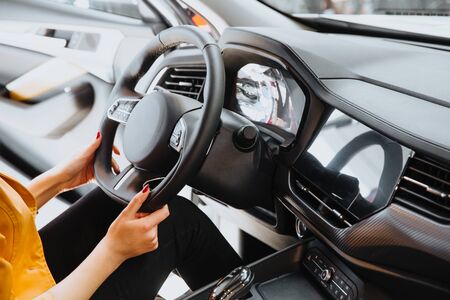 Female hands on the steering wheel of a car while driving. の写真素材