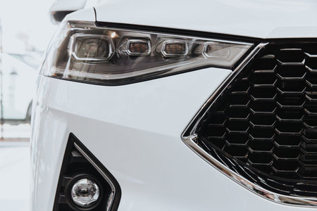 Headlight Of A Modern Car. The car is white.