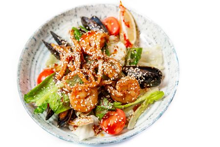 Salad of fresh seafood, mussels, shrimp, fresh vegetables and greens on a white background.の写真素材