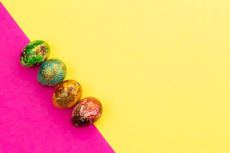 Multi-colored Easter eggs lie in a row.
