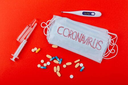 Protective medical mask with the inscription Coronavirus on a red background.の写真素材