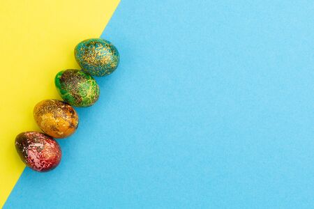 Multi-colored Easter eggs lie in a row.の写真素材