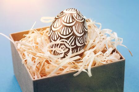 The Easter egg is painted in black and white, an abstraction, lies in a box.の写真素材