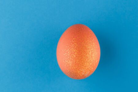 Easter egg painted orange with gold.の写真素材