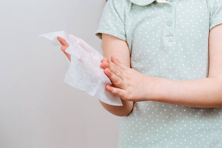 The child wipes her hands wet antibacterial wipe. Clean and hygiene concept.の写真素材