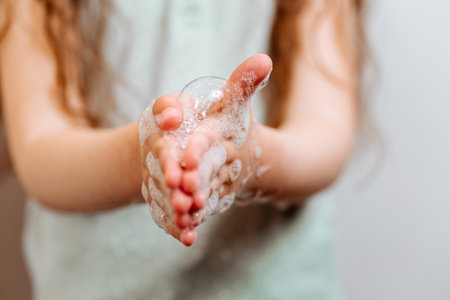 Children's hands in soapy foam. Remember to wash their handsの写真素材