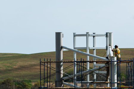 Workers work at a construction site while on scaffolding.Metal construction.