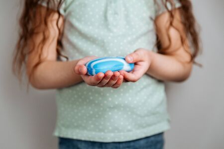 A girl holding soap in her hands.. The importance of personal hygiene.の写真素材