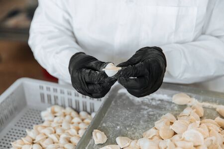 Raw dumplings.The process of cooking. Russian national food. A cook in gloves sculpts them.の写真素材