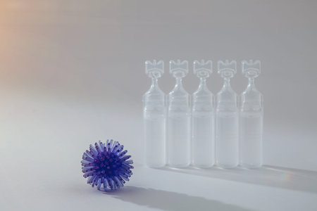 Abstract model of a blue virus infection and medicine in an ampoule on a grey background. Pandemic...