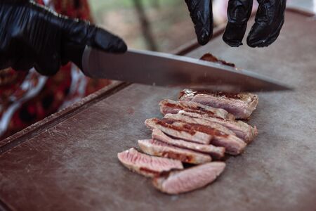 Chef hands slicing juicy steak with a knife.の写真素材