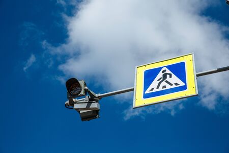 Pedestrian crossing sign and traffic light on cloudy sky background, traffic safety concept.の写真素材