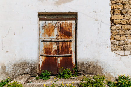 Old door boarded up with a wooden log. Derelict building with boarded doors.の写真素材
