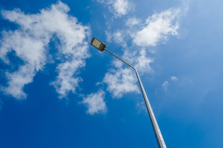 Street lantern on sky with white clouds background.A modern street LED lighting pole.