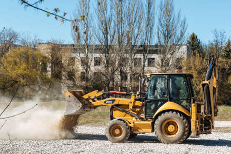 Dneprorudnoe / Ukraine - April 08 2020: A tractor pours the gravel from the bucketのeditorial素材