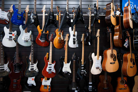 Zaporozhye / Ukraine- March 14 2020: Guitars hang in a row on the store wall.のeditorial素材