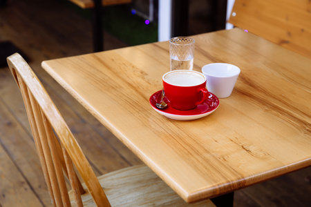 Dirty coffee cups, cappuccino and a glass of water stand on a wooden table. Coffee break. Delight in taste and aroma.の写真素材