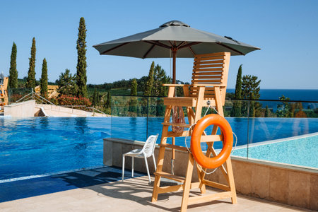 The lifeguards post is under a sun umbrella. A life preserver hangs nearby. Water safety conceptの写真素材