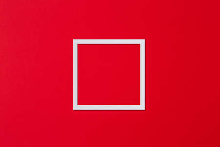 White frame in the form of a square on a red background. Flat lay, copy spaceの写真素材