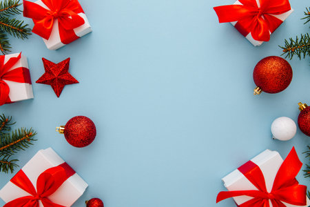 Christmas composition, gifts, fir tree branches, red decorations on blue background, winter, new...