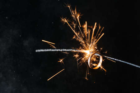 Gold rings with sparklers on a black backgroundの写真素材