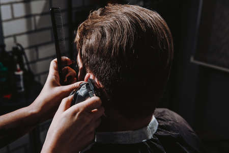 Man getting trendy haircut in barber shopの写真素材