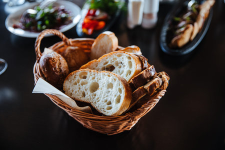 Different types of bread in the basket on the table in the interior of the restaurant