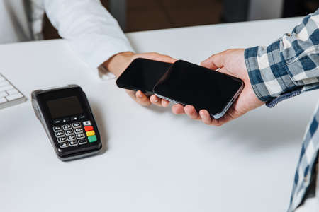 Horishni Plavni, Ukraine - 07, Juny 2022 : Tap to pay. iPhone is used as a payment terminal.のeditorial素材