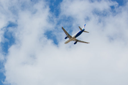 White- blue passenger airplane flying in the sky amazing clouds in the background