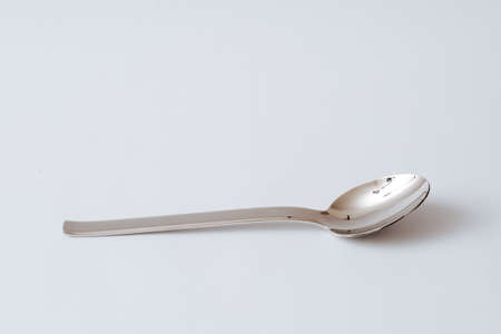 Stainless steel teaspoon on white background, kitchenware, copy space, close-upの写真素材