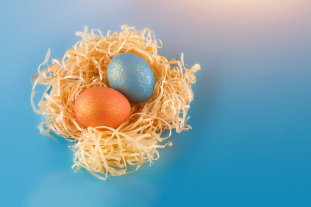 Easter eggs are painted blue with gold and orange gold.の写真素材