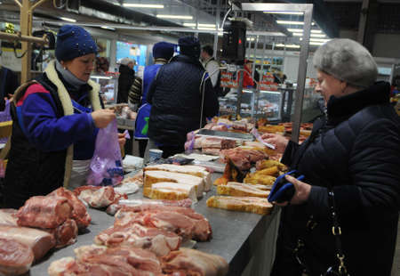 The buyer near the meat counter in the covered part of the Vladimir market in Kiev, January 22, 2019.のeditorial素材