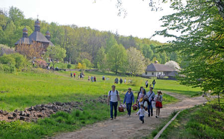 People carry Easter baskets at the Pirogovo National Museum of Folk Architecture and Life of Ukraine, in Kiev, April 28, 2019.のeditorial素材