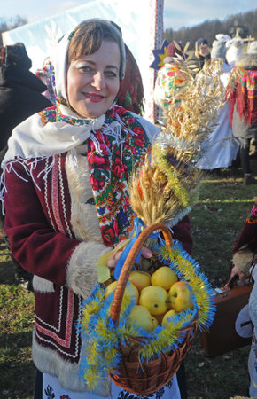 A participant in the meeting with St. Nicholas ethnographic entertainment program holds a basket of apples at the National Museum of Folk Architecture and Life of Ukraine in Pirogovo, January 12, 2020のeditorial素材