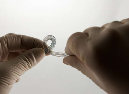 surgeon's hands twisting self-expanding braided nitinol stent for endovascular surgeryの写真素材
