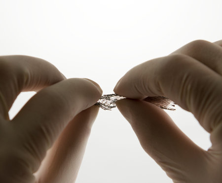 surgeon's hand compressing self-expanding nitinol meshed stent for endovascular surgeryの写真素材