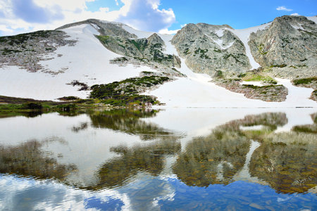 Snowy Range Mountains and alpine lake with reflection in Medicine Bow, Wyoming in summer