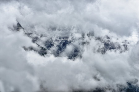 high and steep mountain surrounded by heavy clouds in Glacier National Park