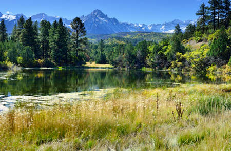 landscape view of the lake and snow covered mountains in the colorful alpine scenery during foliage seasonの写真素材