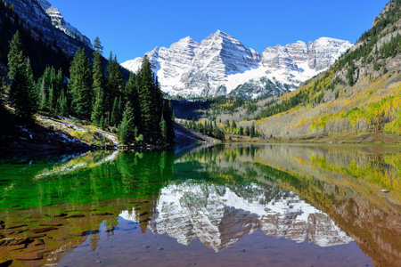 landscape view of the Maroon Bells during foliage season with snow covered mountains and yellow aspen reflecting in the lake, Coloradoの写真素材