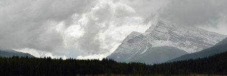High mountains of the Canadian Rockies surrounded by clouds along the Icefields Parkway between Banff and Jasperの写真素材