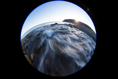 The river flows into the sea. Circular fisheye seascapeの写真素材