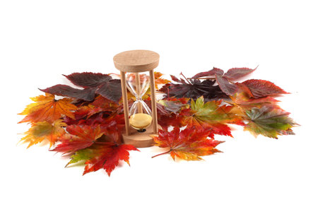 Sandglass and autumn fallen leaves