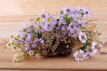 Honey and flowers on table