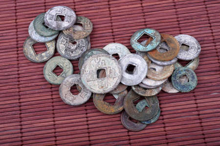 Ancient Chinese coins on bamboo background. Symbol of luckの写真素材
