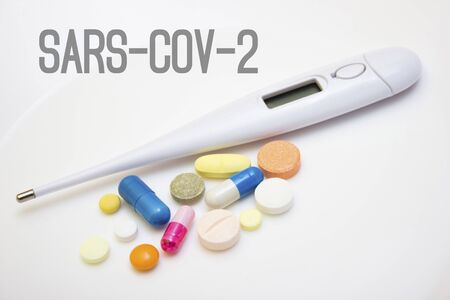 Electronic thermometer with tablets and capsules on a white background - protection against influenza during quarantine, coronavirus, covid19の写真素材