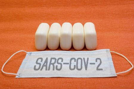 Many pieces of solid soap and a protective mask - protection against influenza during quarantine, coronavirus, covid19, lettering sars-cov-2の写真素材