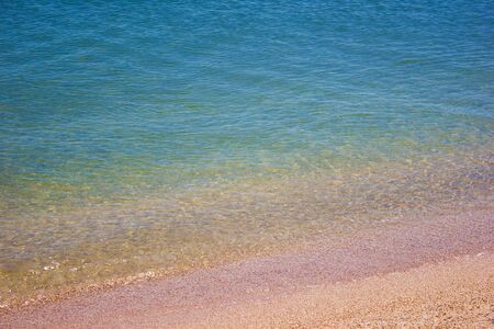 Shore beach water sea wave sand shells, vacation background textureの写真素材